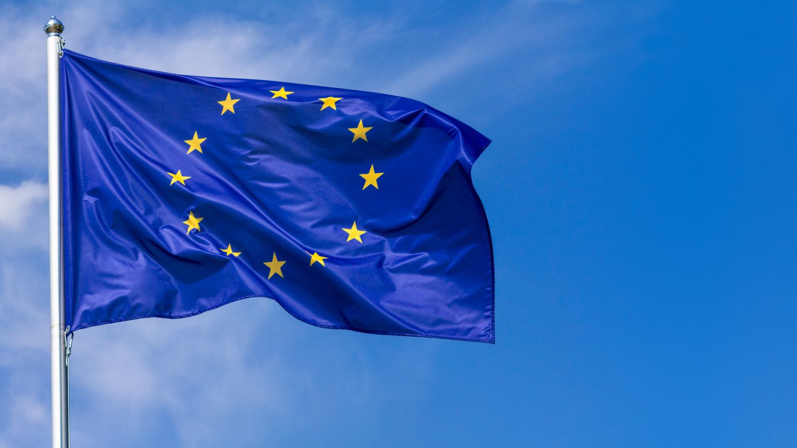 Wehende EU-Fahne vor blauem Himmel mit Schleierwolken
